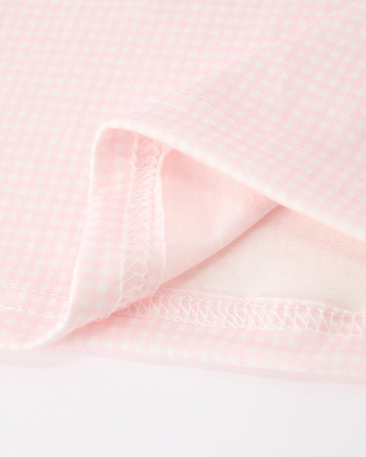 Pink baby girl dress fabric close-up with textured check lining detail