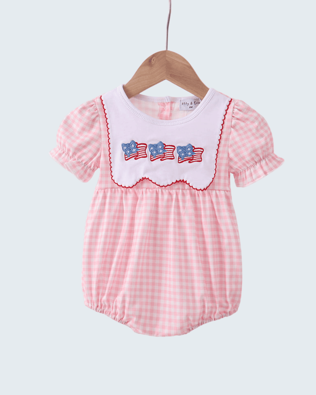 Pink checkered baby romper with American flag design on a white background