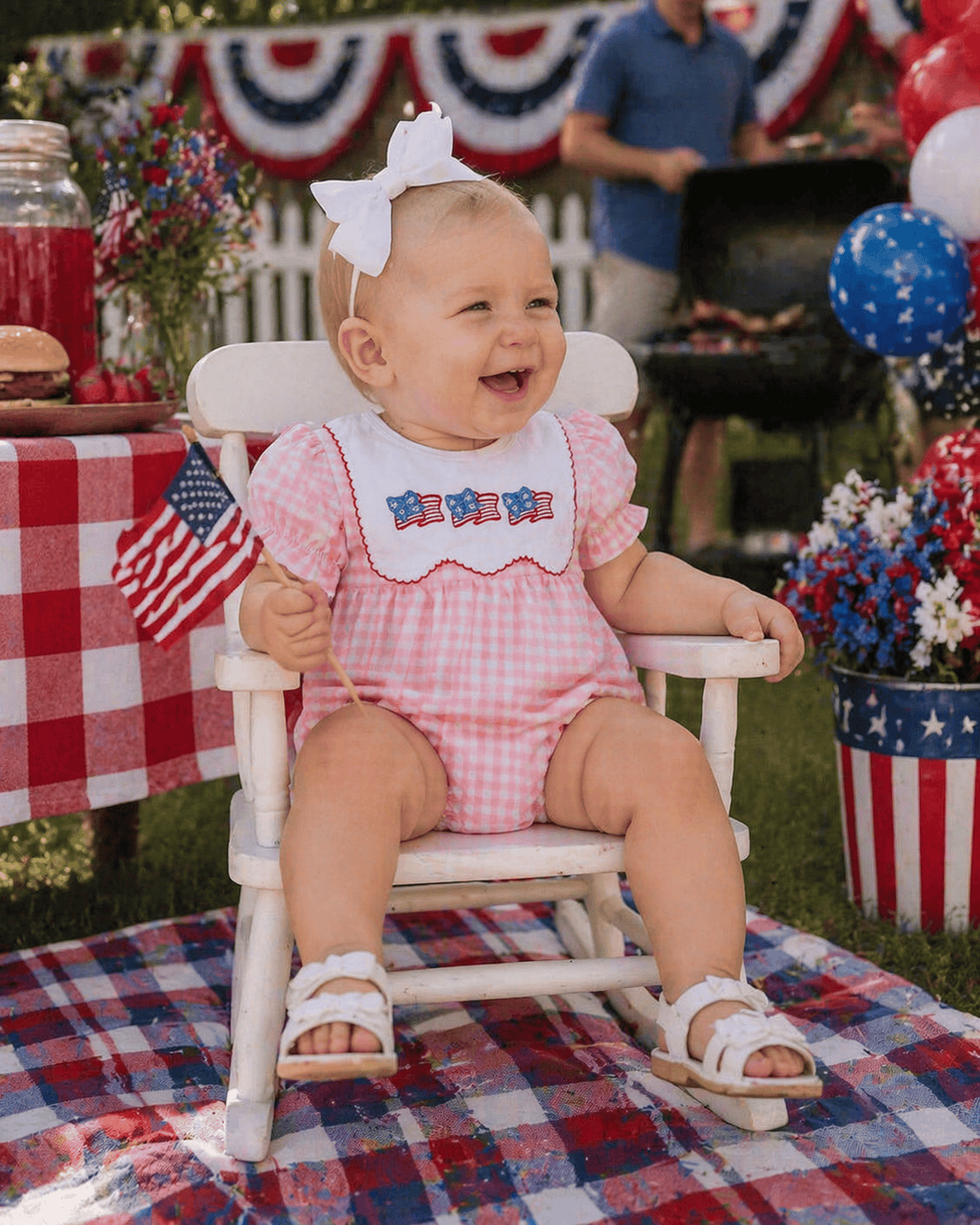 Baby in a high chair wearing a patriotic outfit with a 4th of July theme.