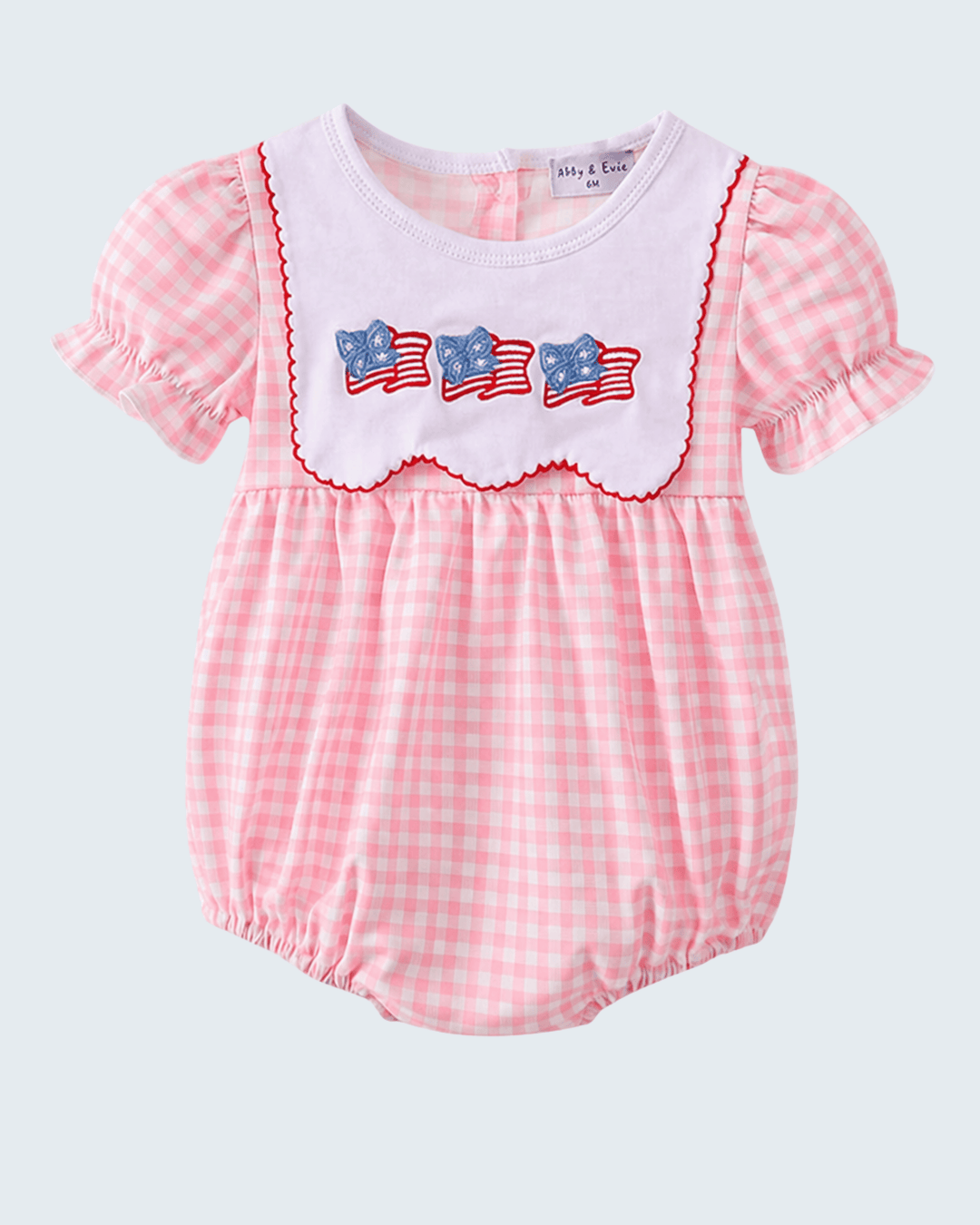 Pink checkered baby romper with American flag design on a white background