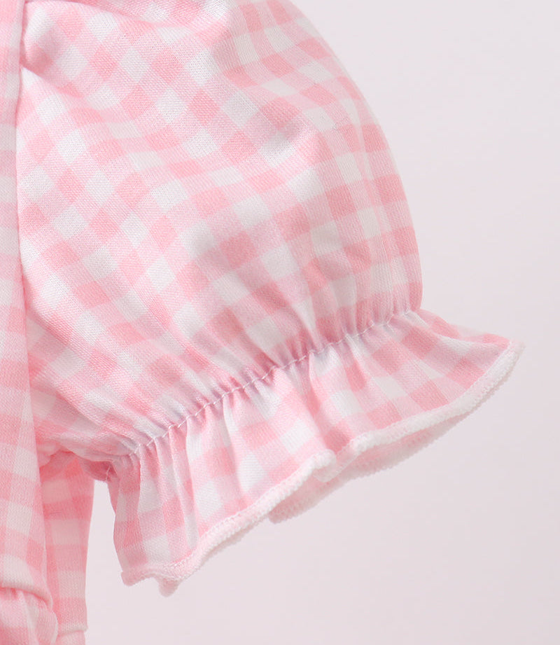 Close-up of pink and white checkered fabric on a light pink background