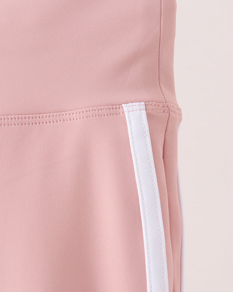 Pink active pants detail: white side stripe panel at leg opening