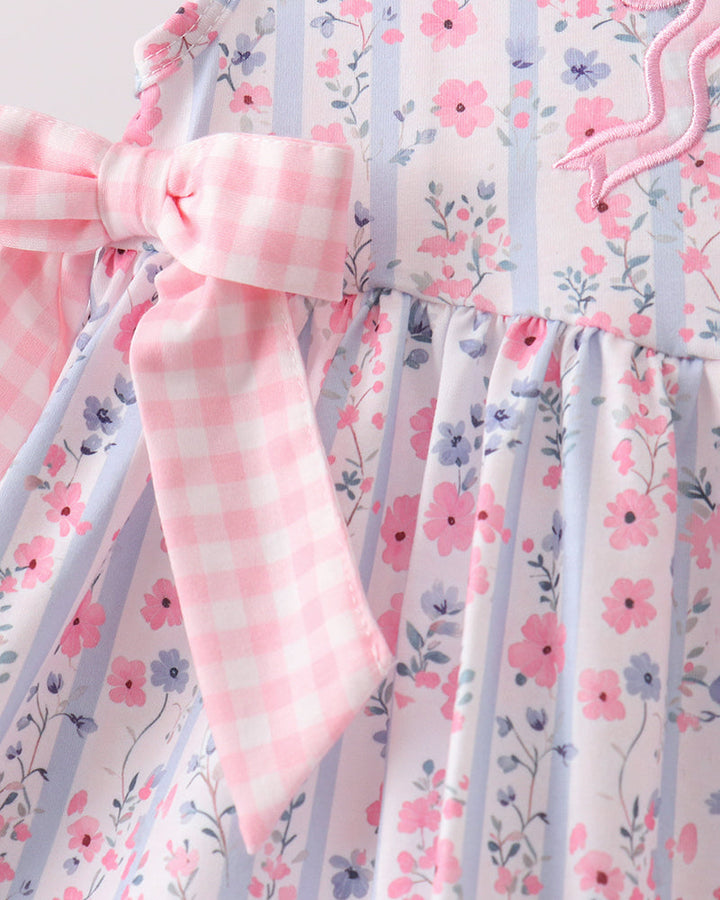 Floral dress with pink checkered sleeves and trim on a white background