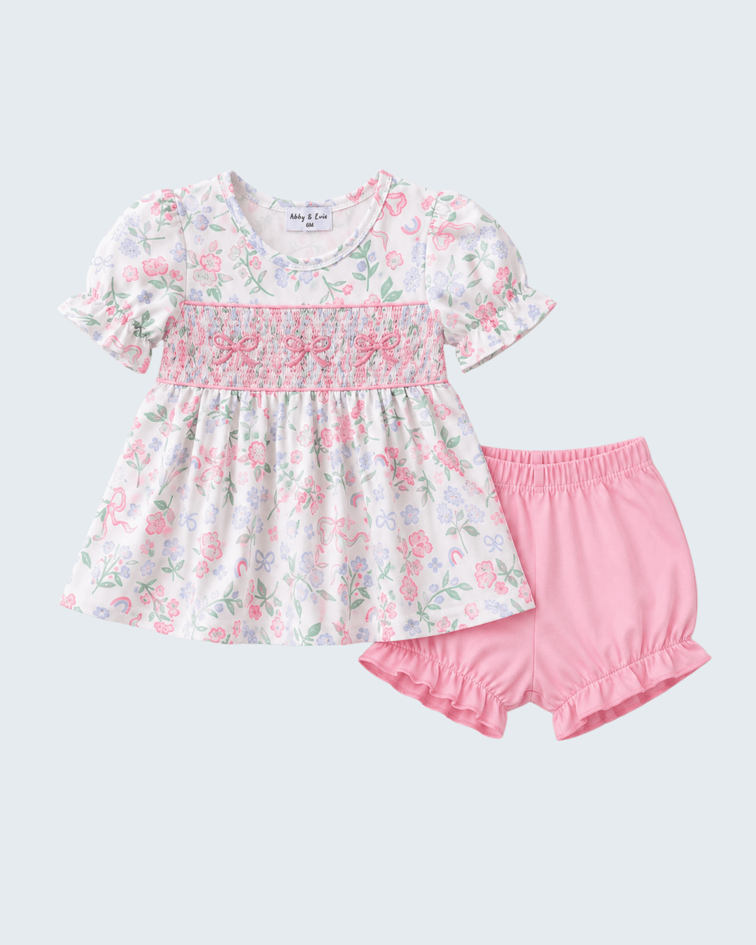 Floral top and pink shorts set on a light gray background