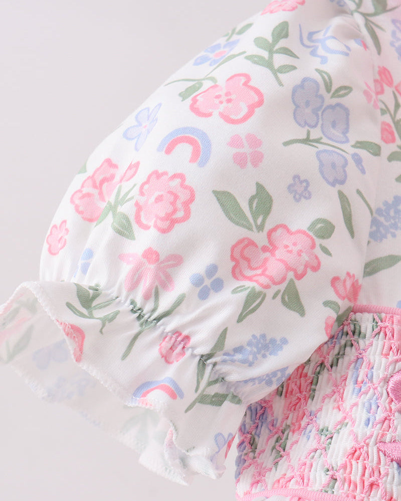 Floral-patterned fabric with pink flowers and green leaves on a white background