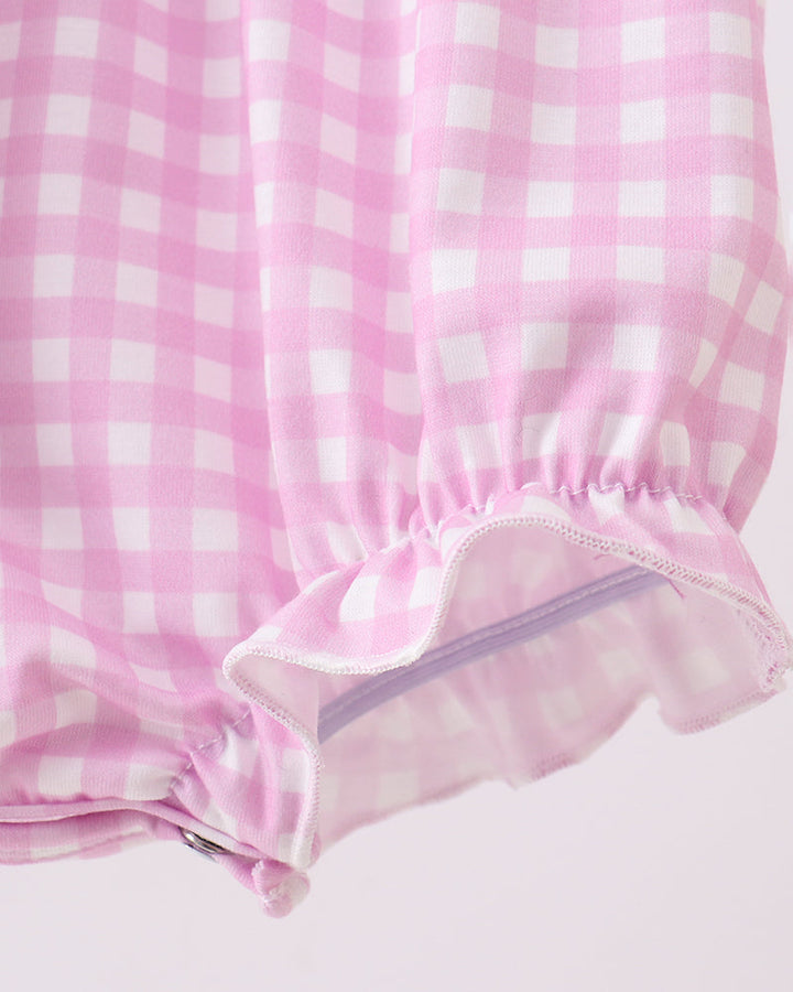 Close-up of pink checkered fabric on a light pink background