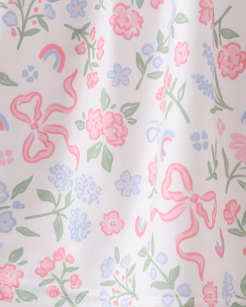 Floral and bow patterned fabric with pink bows and colorful flowers on a white background