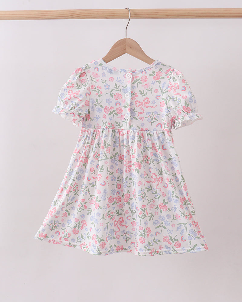 Floral dress on a hanger against a plain background