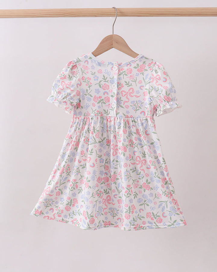 Floral dress on a hanger against a plain background
