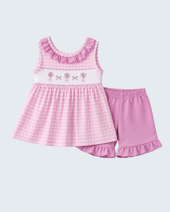 Pink checkered dress with ruffled shorts on a light purple background