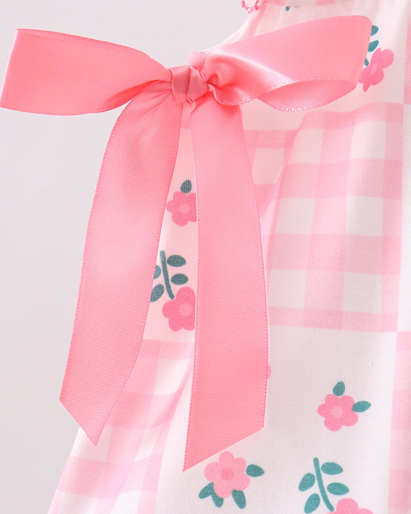 Pink and white checkered dress with floral patterns and a large pink bow on a light gray background