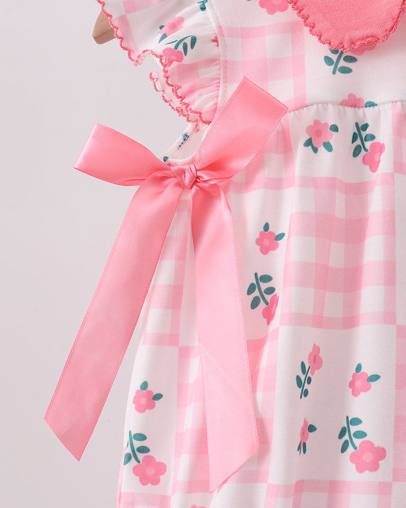 Pink and white checkered dress with floral patterns and a large pink bow on a light gray background
