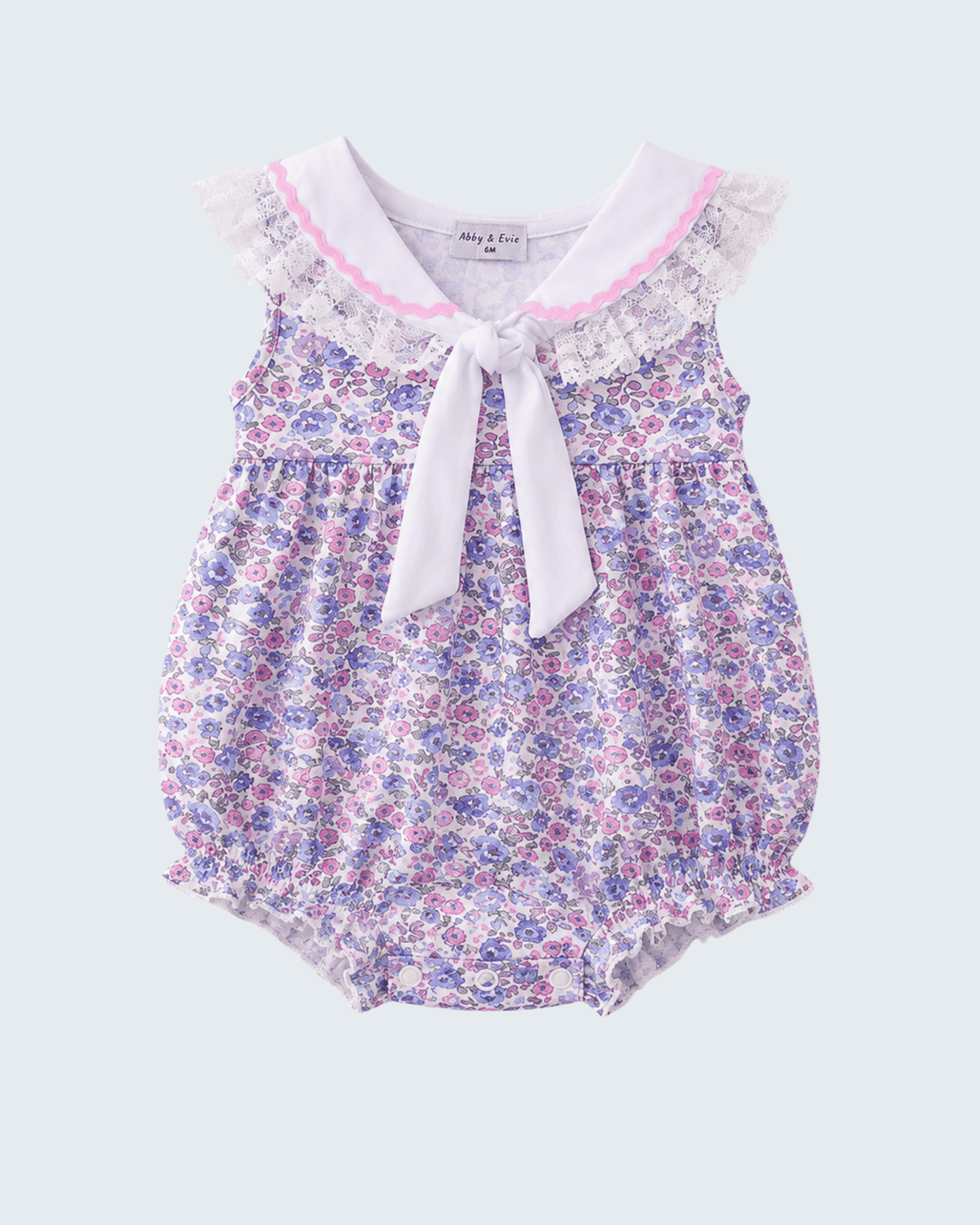 Floral baby romper with lace trim on a light gray background