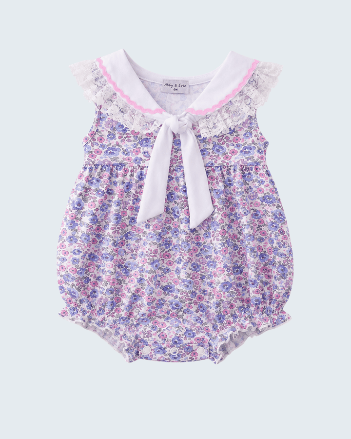 Floral baby romper with lace trim on a light gray background