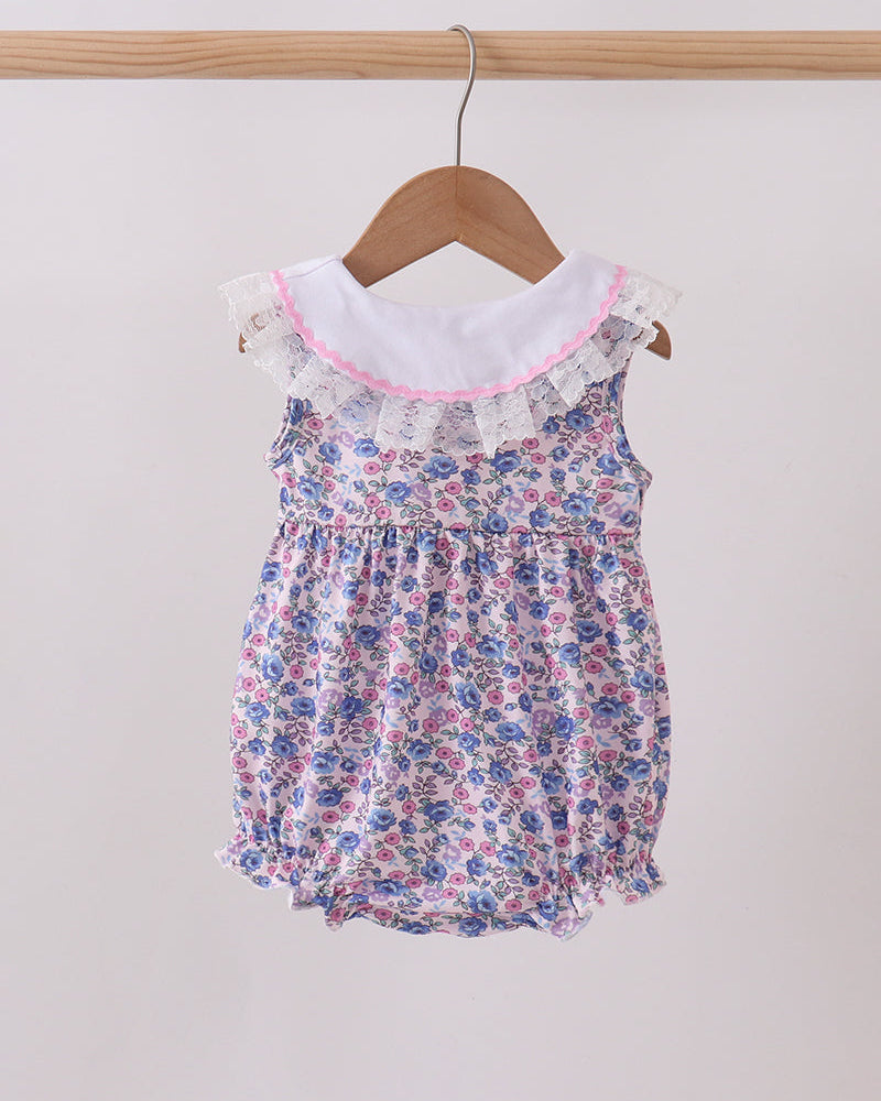 Floral baby romper on a hanger against a white background
