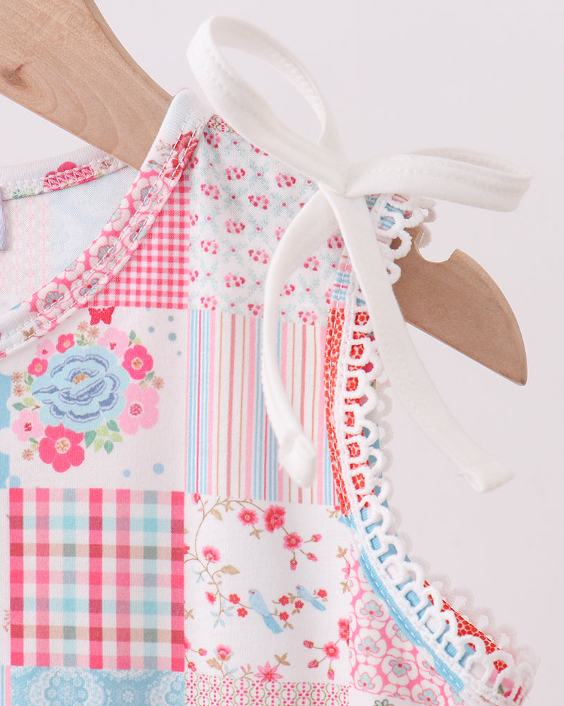 Colorful patchwork dress with floral and geometric patterns on a white background