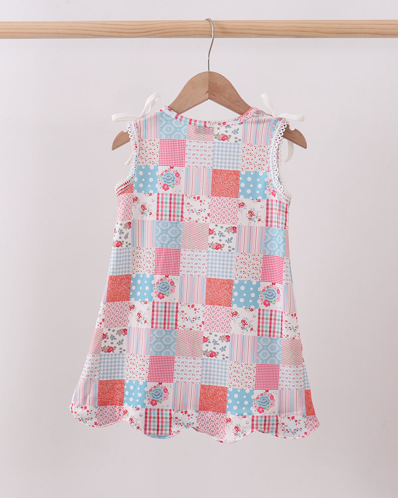 Patchwork dress on a hanger against a white background