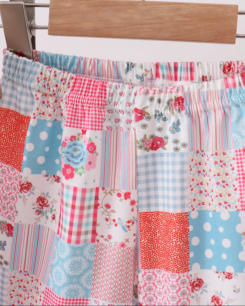 Patchwork skirt with floral, polka dot, and plaid patterns hanging on a wooden hanger.