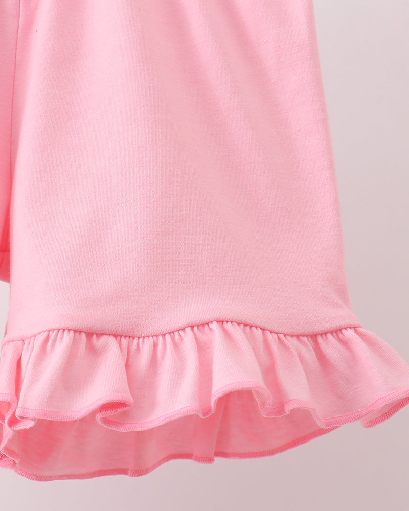 Close-up of a pink shorts with ruffled hem on a light gray background