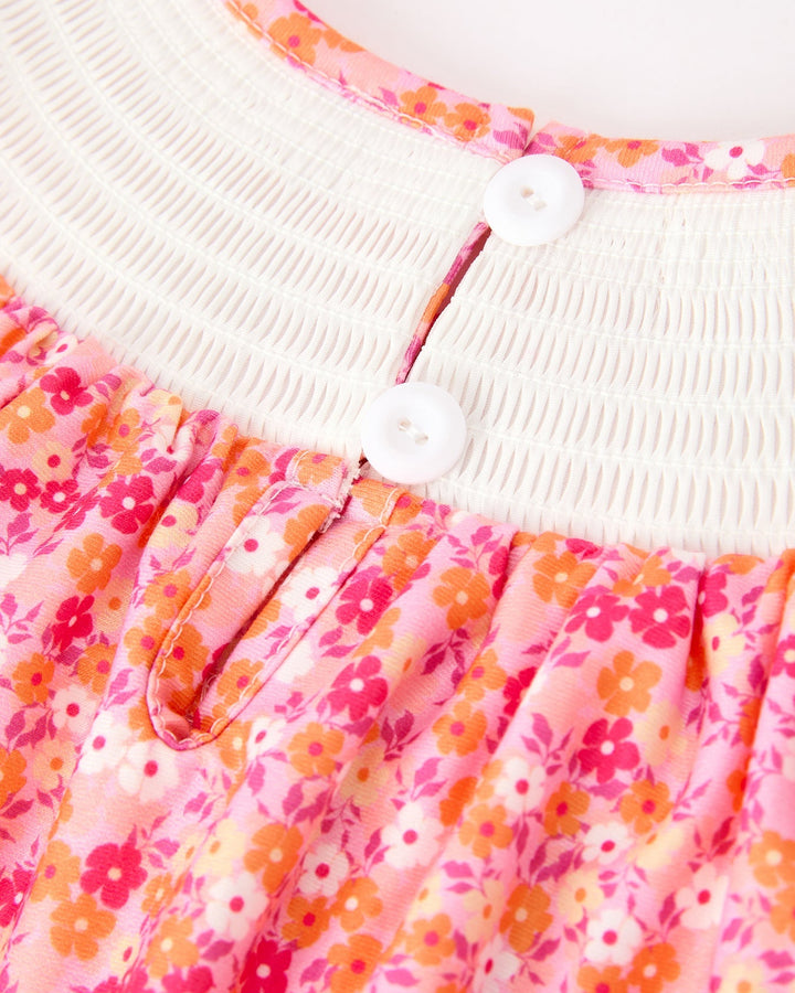 Close-up: white smocked neckline with two-button placket on pink floral twirl dress