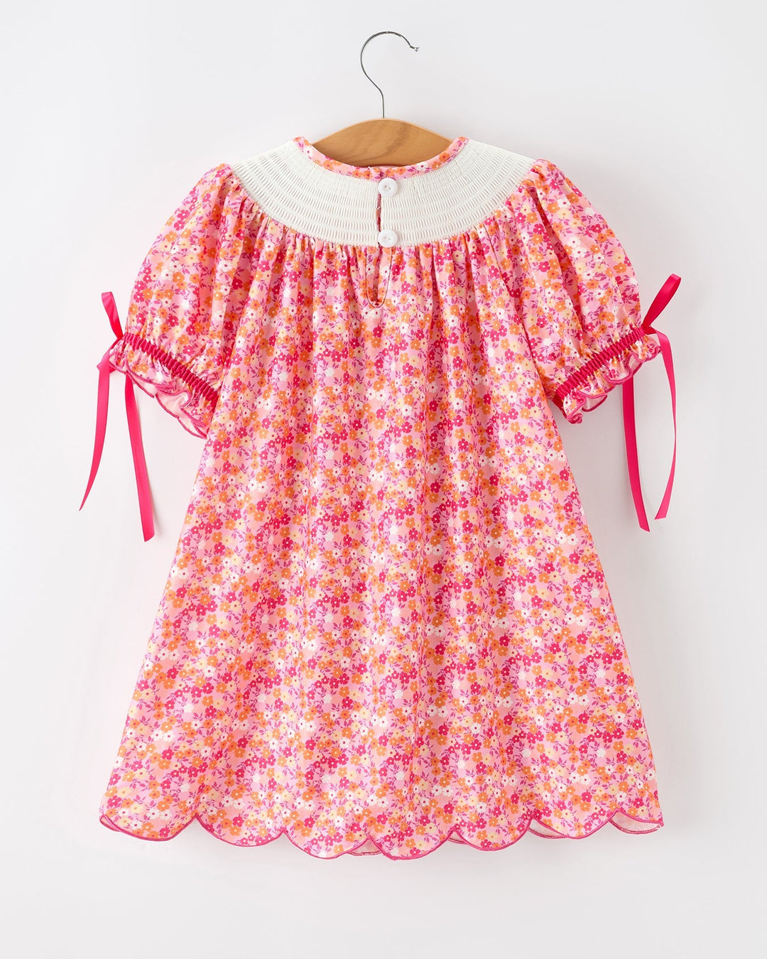 Girls hot pink floral twirl dress with white smocked yoke and ribbon-tied puff sleeves