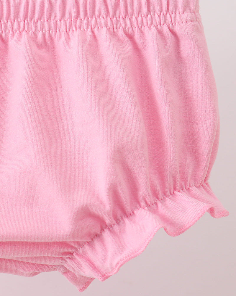 Close-up of pink baby bloomers on a light gray background
