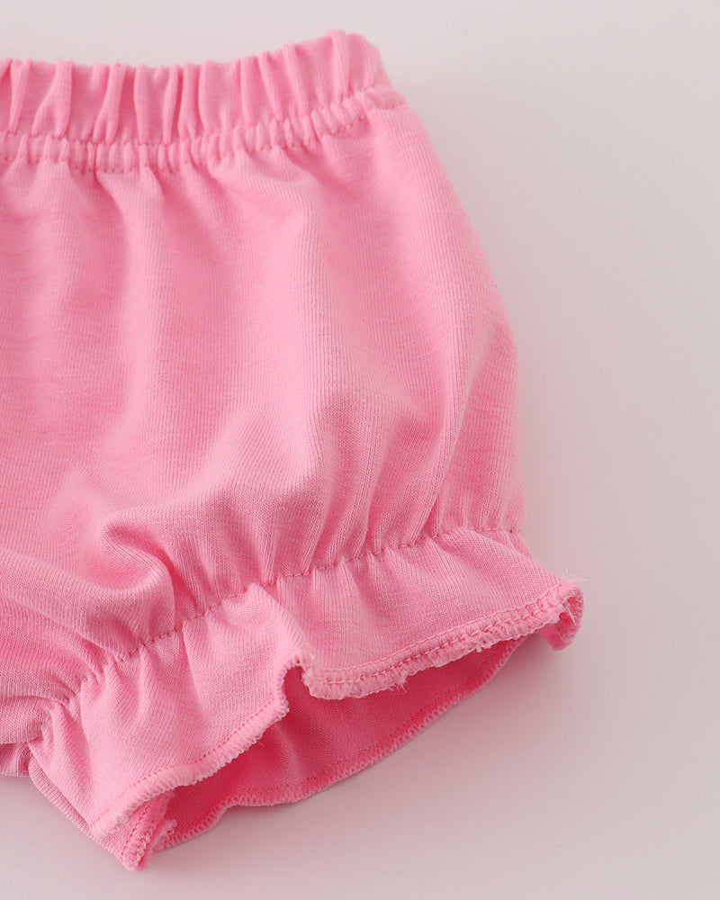 Pink baby bloomers on a light gray background