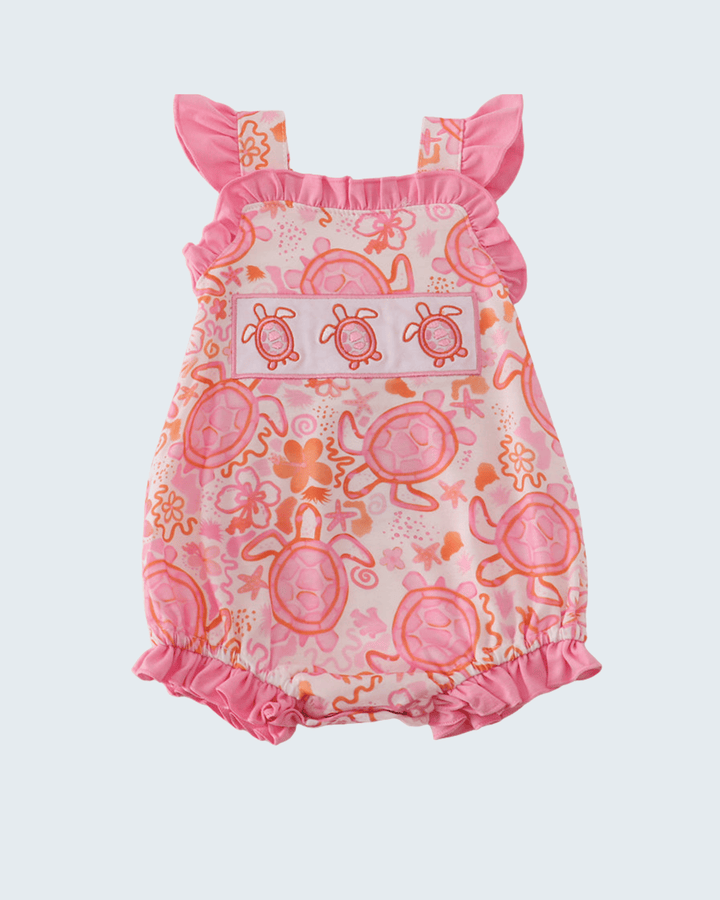 Pink baby romper with turtle pattern on a light gray background