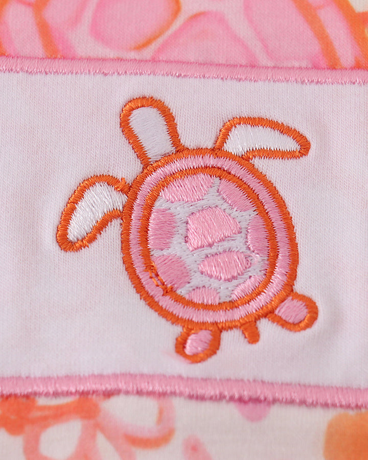 Close-up of a pink and orange turtle design on fabric