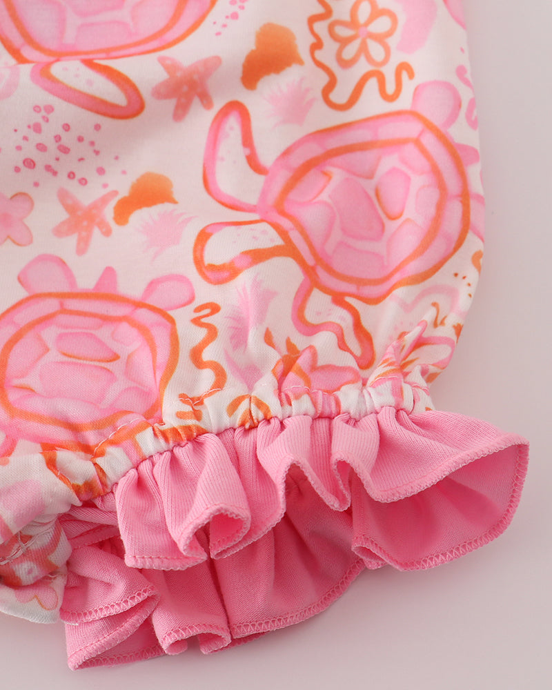 Pink and orange floral-patterned baby romper with ruffled hem on a light background