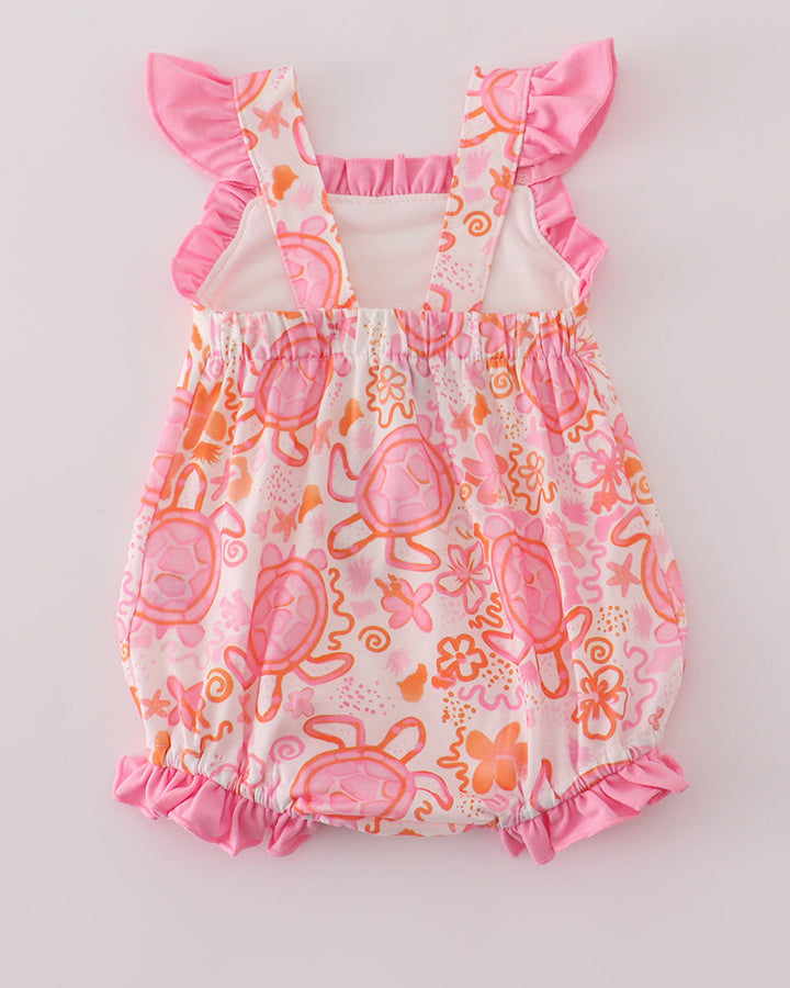Baby romper with pink and orange turtle pattern on a light gray background