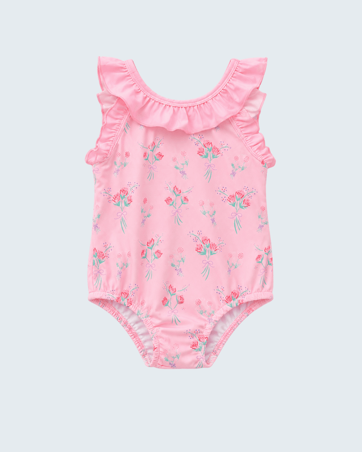 Pink floral baby swimsuit with ruffled details on a light gray background