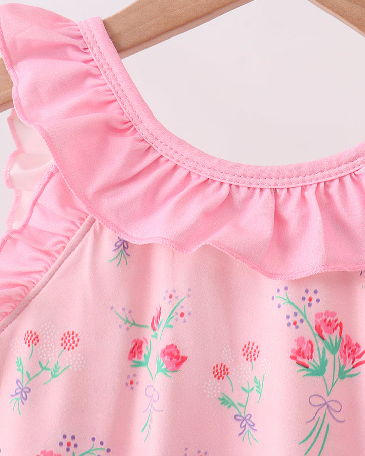 Pink swimsuit with floral embroidery on a wooden hanger
