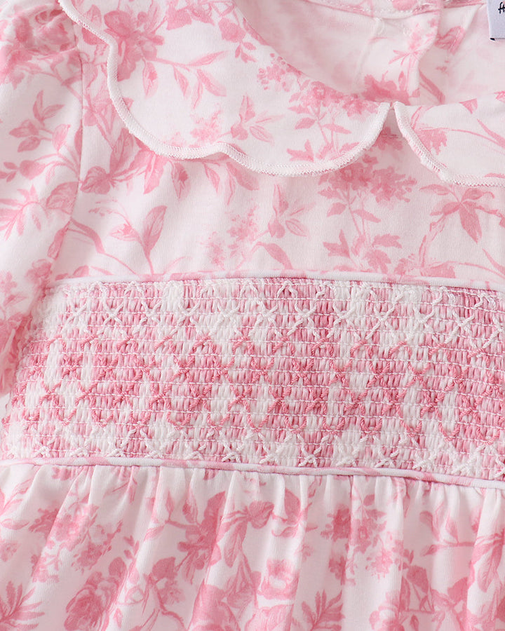 Close-up of pink floral smocked bodice and ruffled waist with elastic gathers