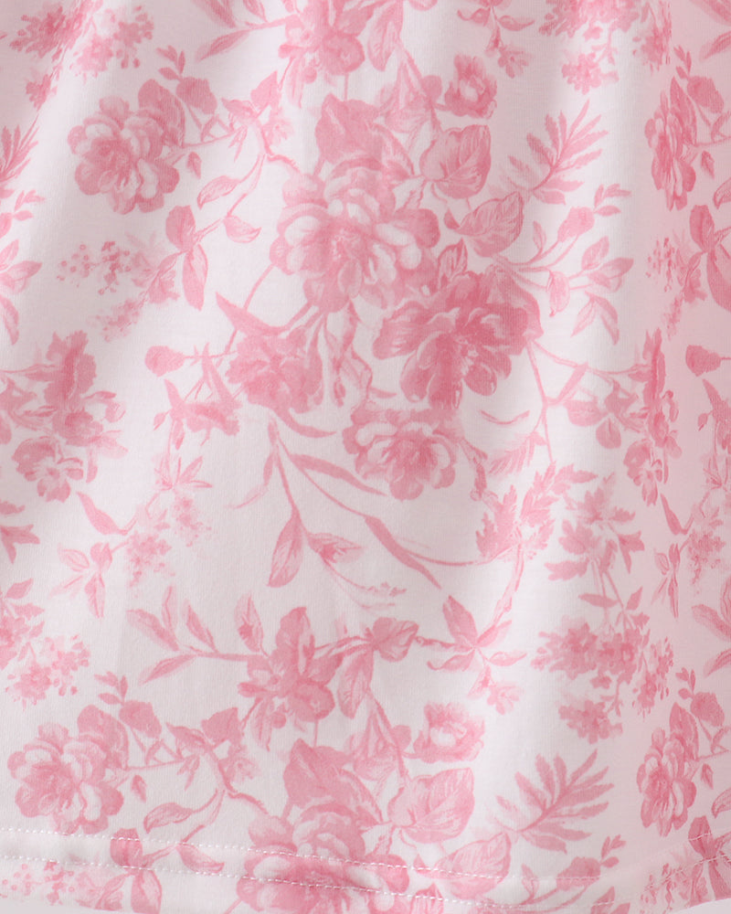Pink floral skirt fabric with soft gathers at hem, fully shown in close-up