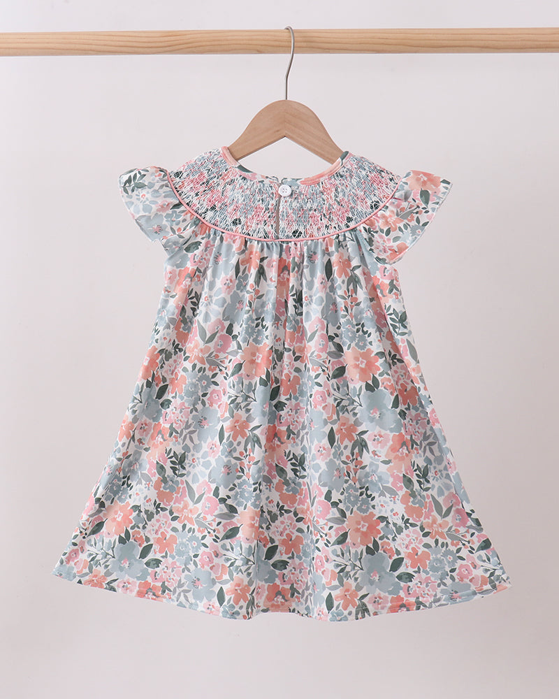 Floral dress on a hanger against a plain background