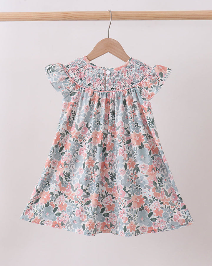 Floral dress on a hanger against a plain background