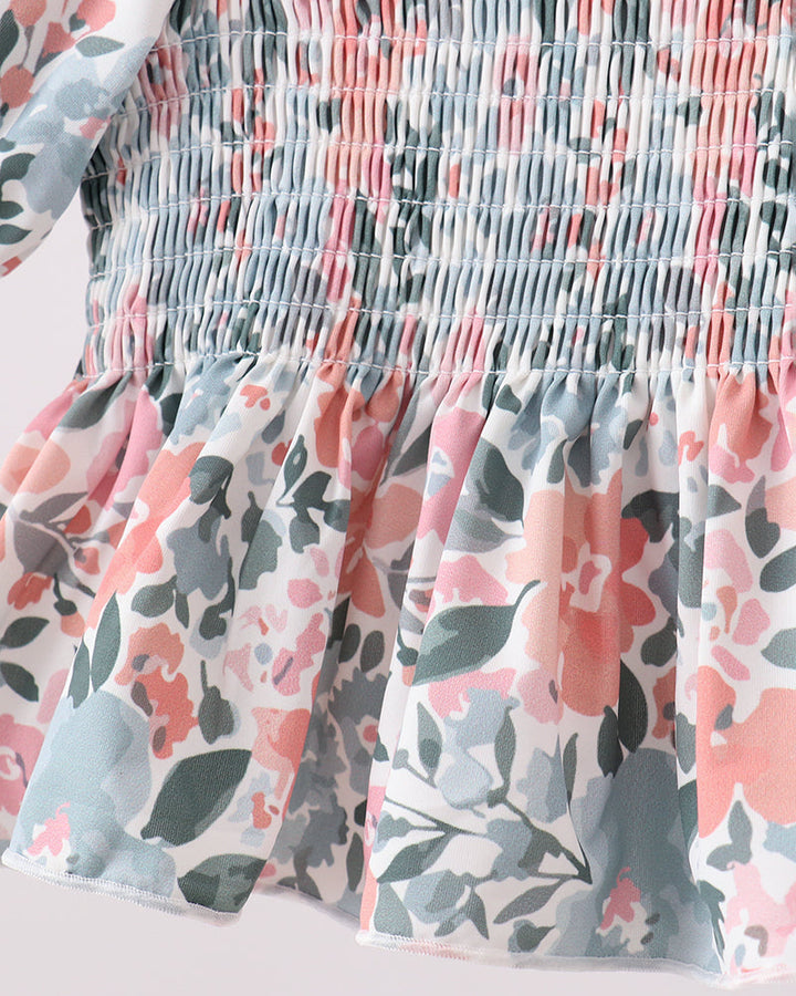 Floral patterned swim top with smocked waistband on a light background