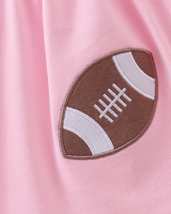 Brown and white football applique patch with stitched outline on pink
