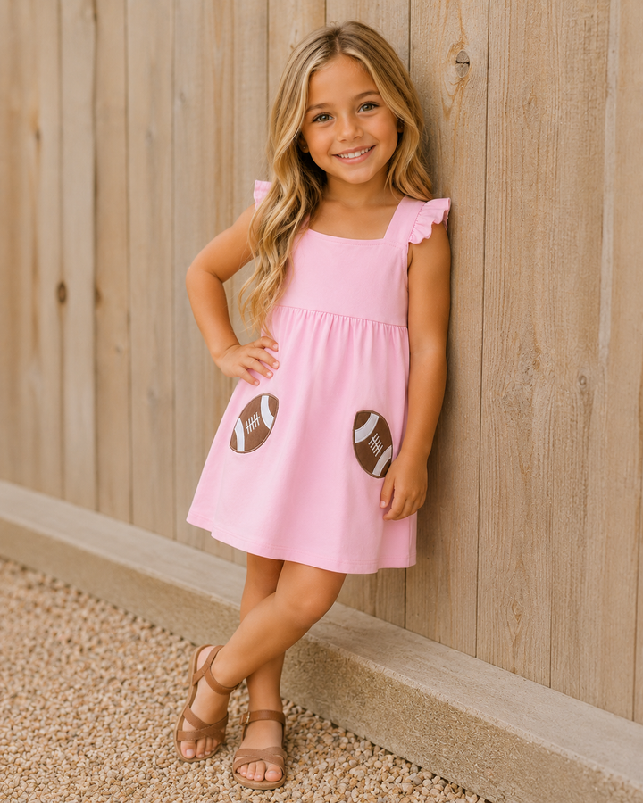Pink dress with football patches, ruffle trim, and sleeveless design