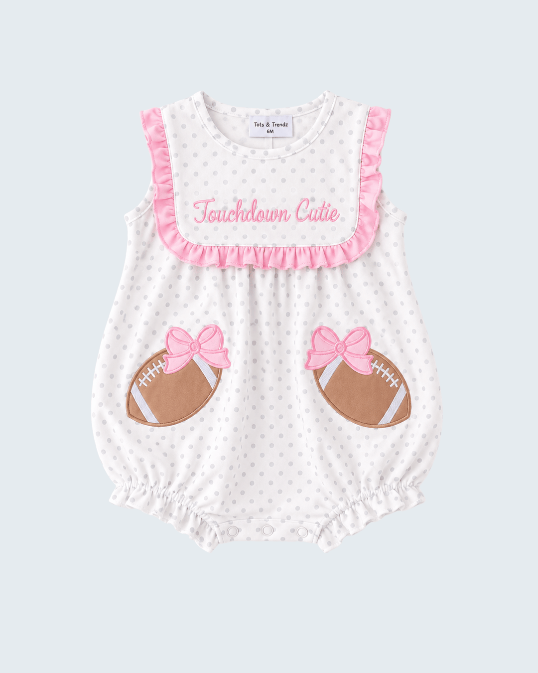 White polka-dot baby romper with pink ruffle trim, 'Touchdown Cutie' and bow footballs