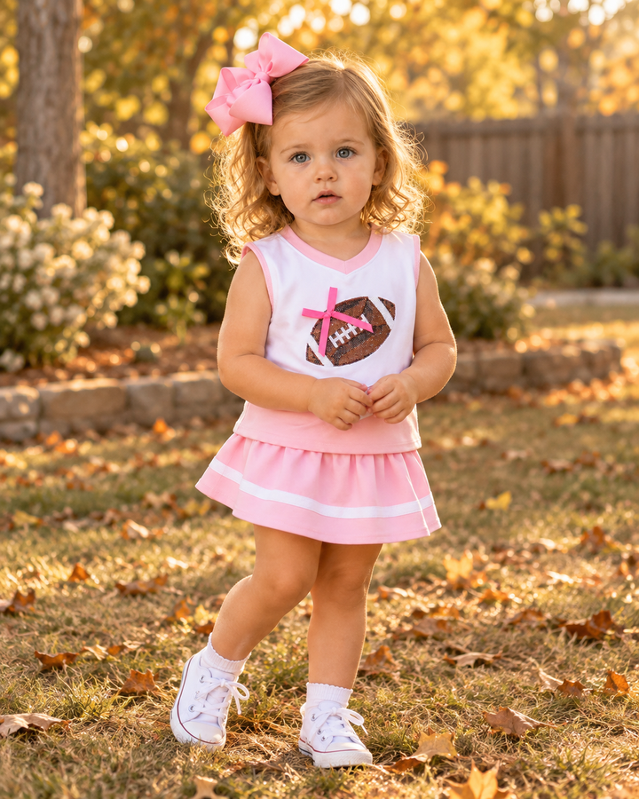Child wearing pink striped sleeveless skort set with sequin football heart and bow