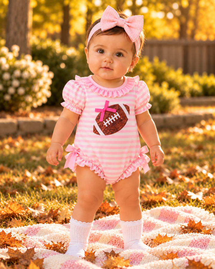 Baby girl in pink and white striped romper with football sequin patch, pink bow headband