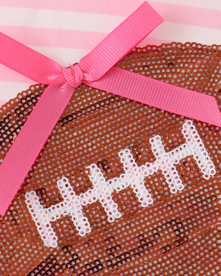 Sequin football patch with pink bow on pink-and-white striped dress