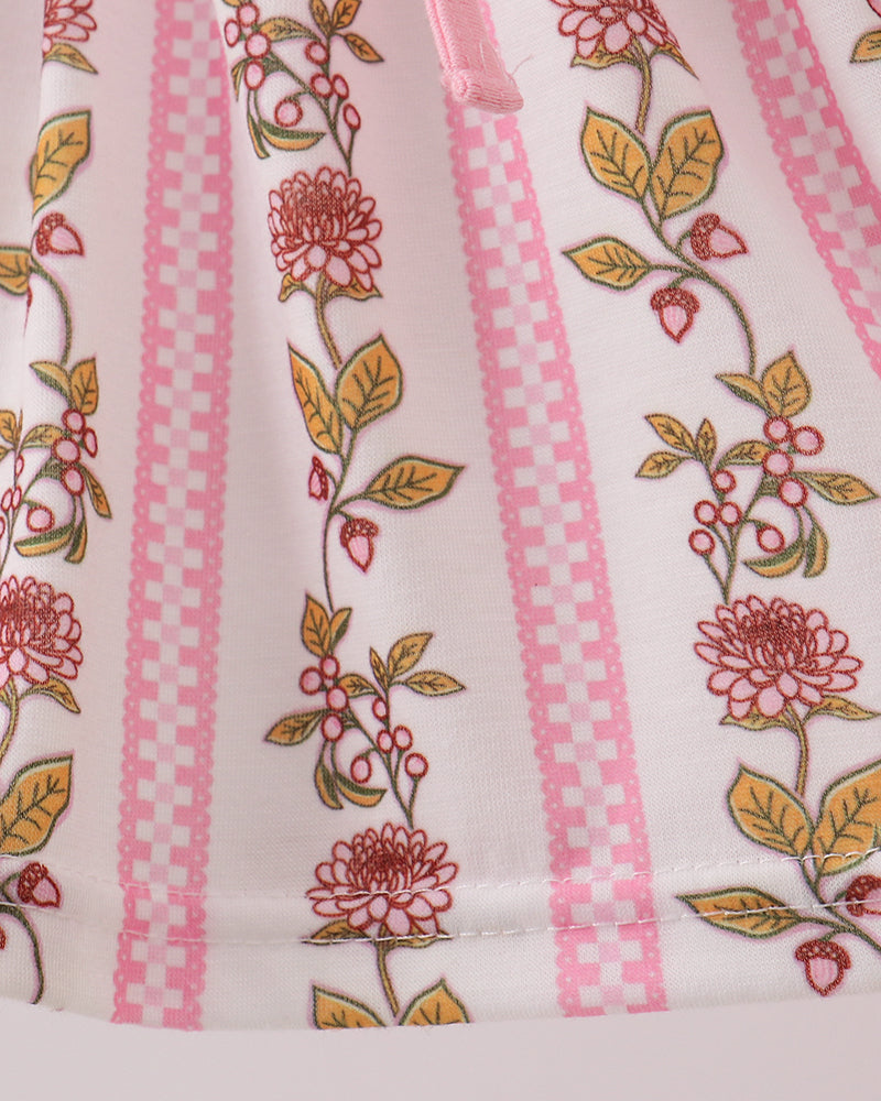 Close-up of a fabric with floral patterns and pink stripes on a white background