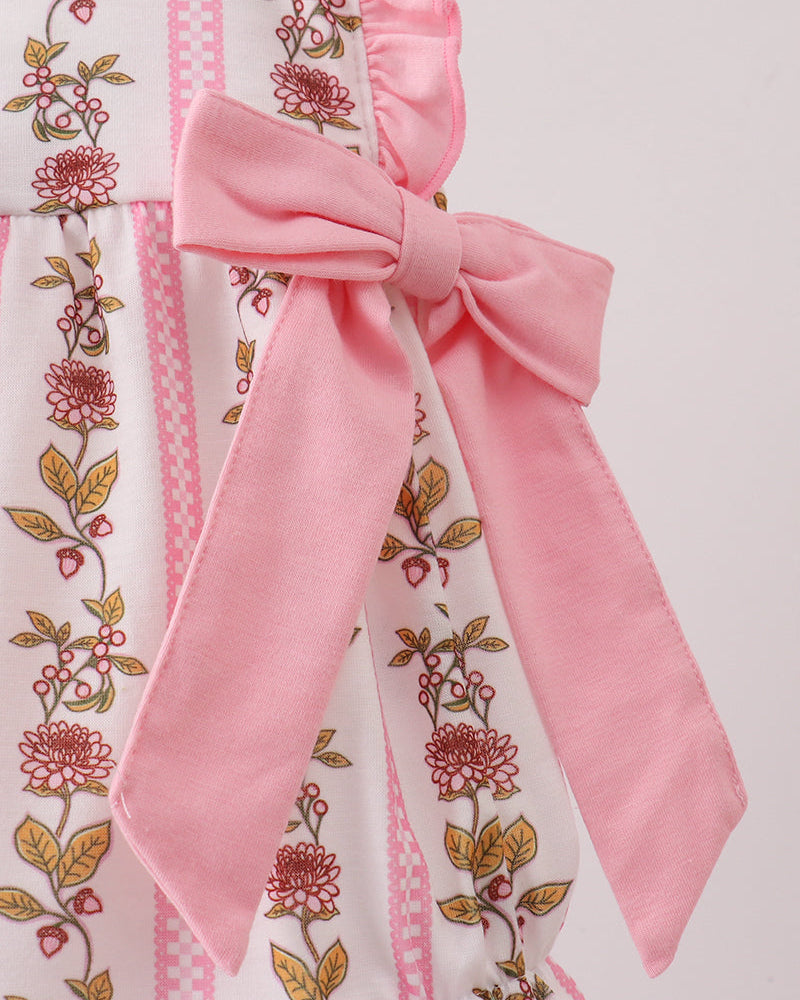 Floral romper with a large pink bow on a light background