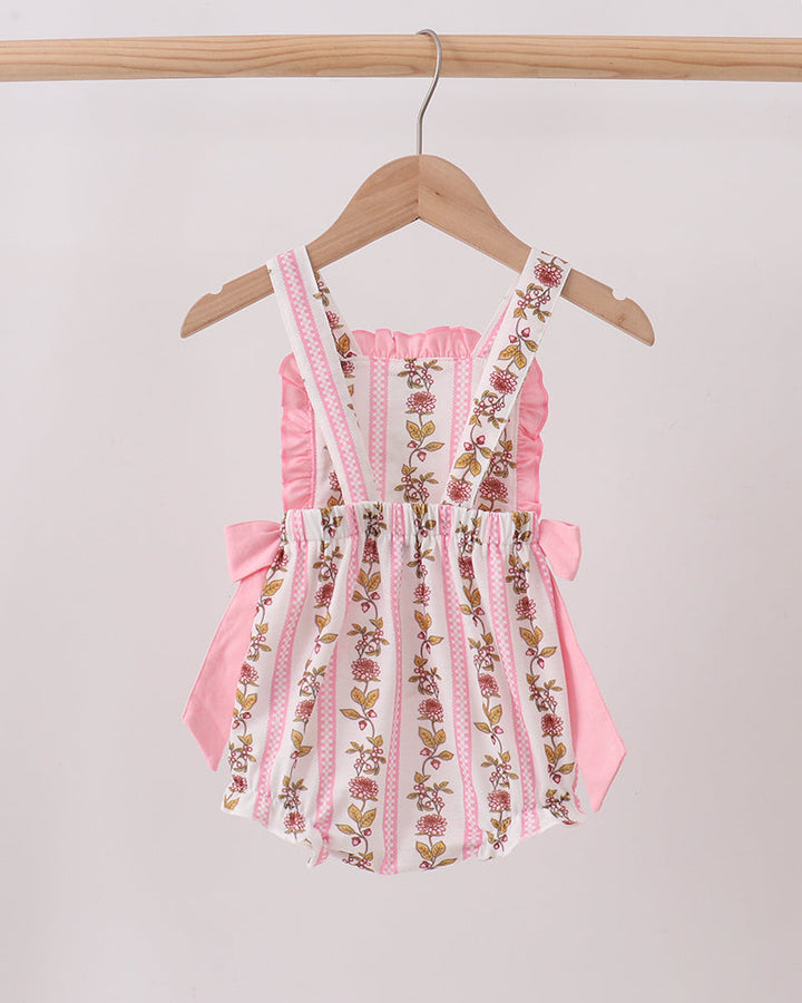 Pink floral embroidered romper on a hanger against a light background