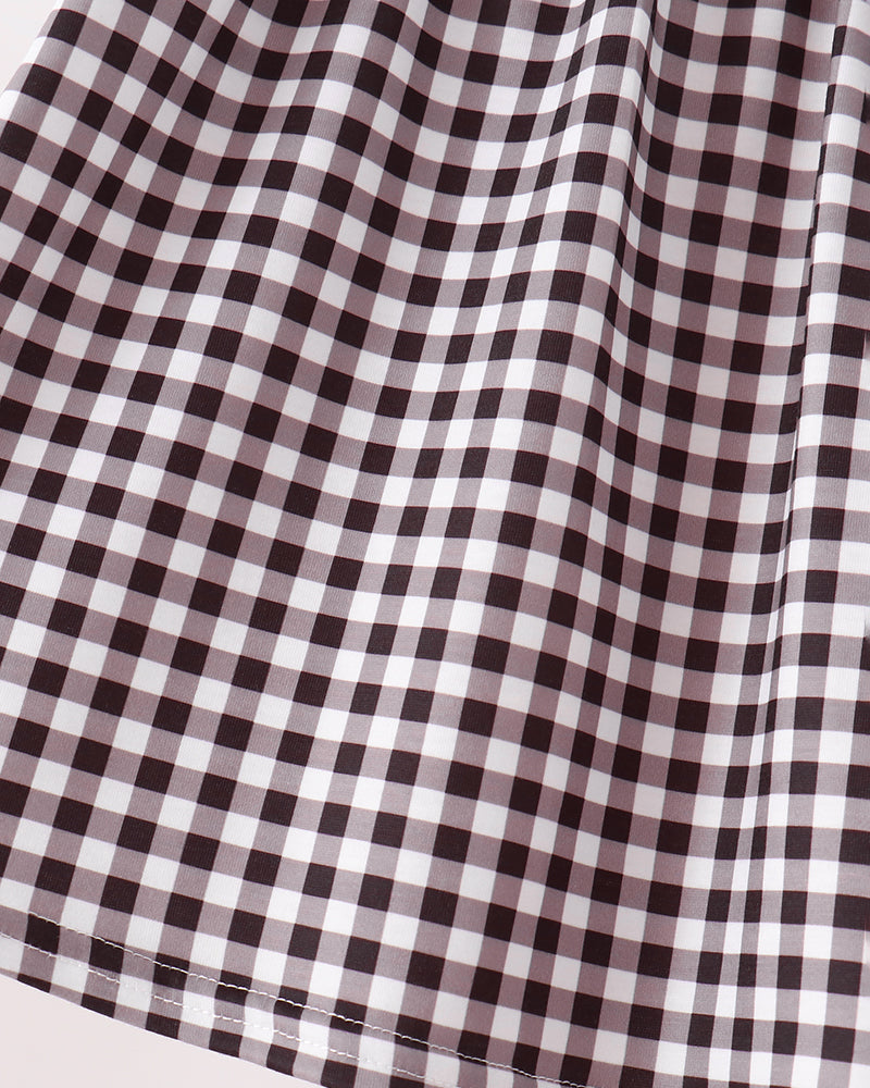 A close-up of a black and white gingham checkered fabric, showing the texture and pattern of the checkered squares.