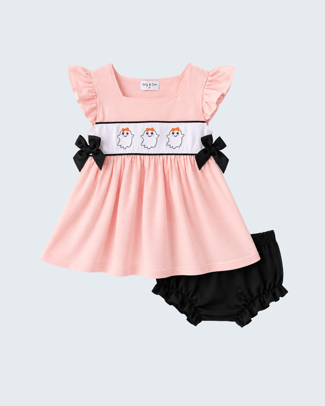 A baby girl's two-piece outfit set featuring a light pink dress with ruffled sleeves, a white smocked band with three cartoon ghosts, and black bow accents, paired with black bloomers, on a light gray background.