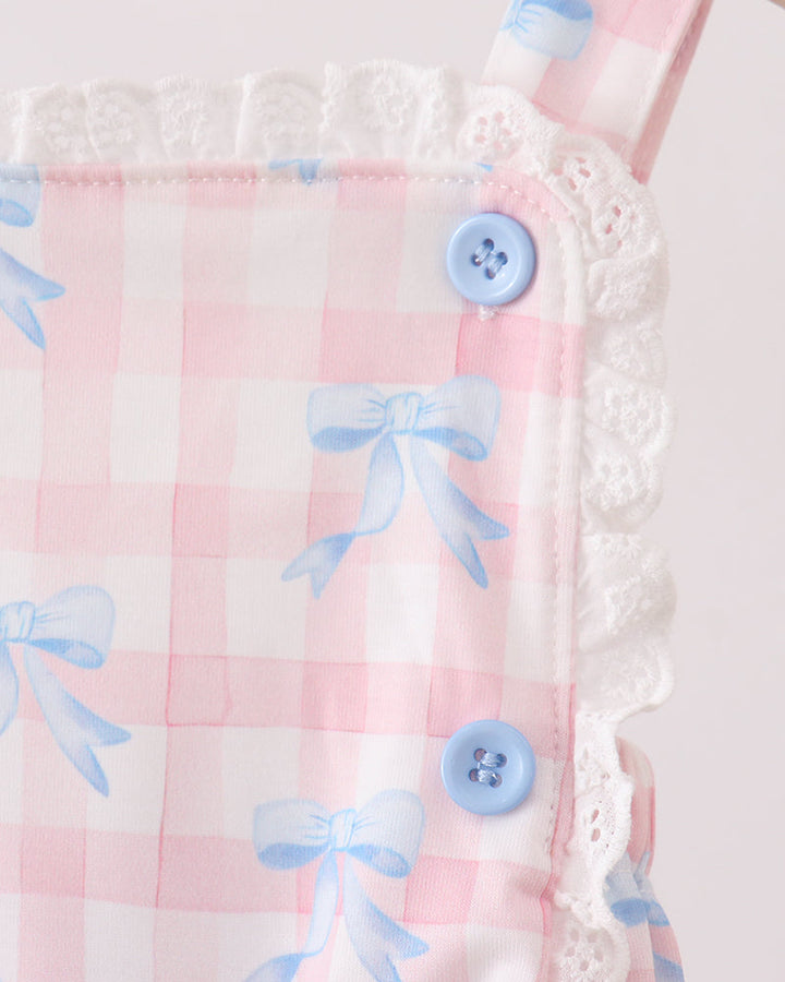 Pink fabric with blue bows and buttons on a white background